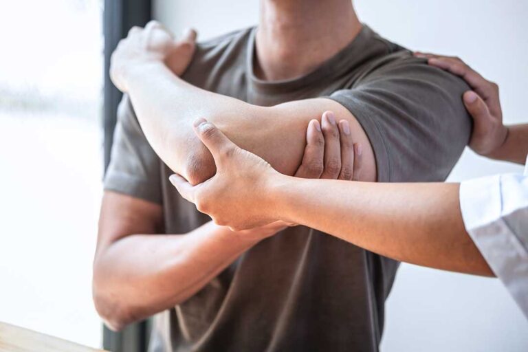 Athlete performing a balance exercise while a clinician observes hip and ankle alignment.